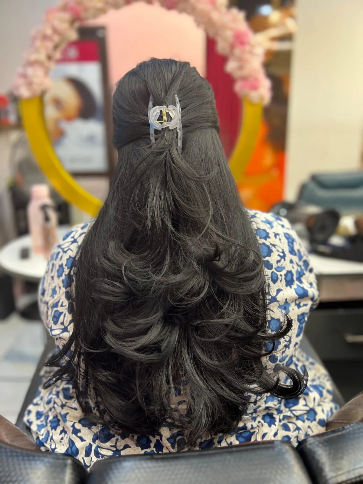 Long layered haircut with voluminous curls, back view